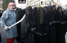 عکس/ فروش زنان کنیز با دستان زنجیز شده توسط مرد شمشیر زن !